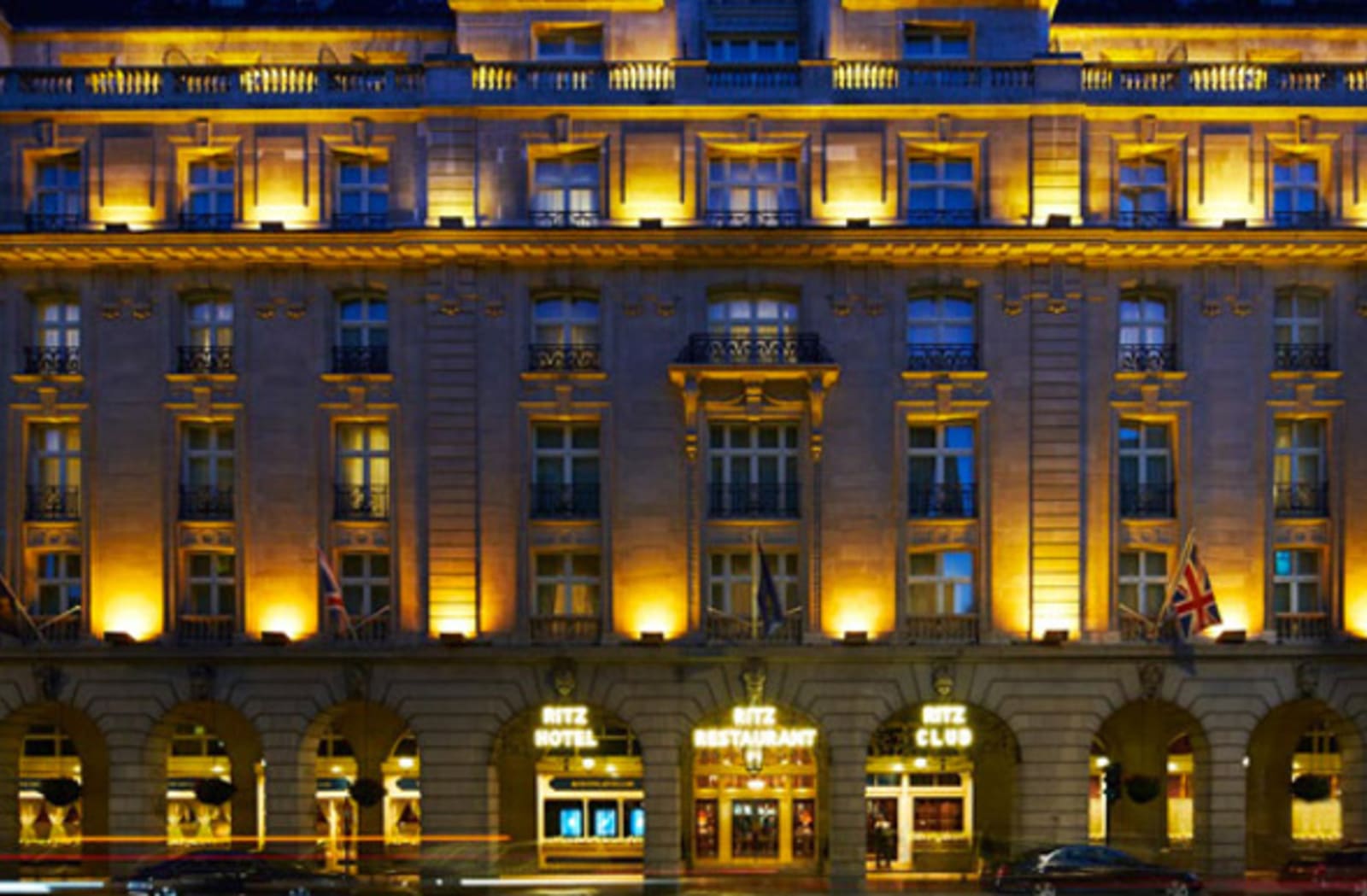 The Ritz hotel in the late afternoon, lit up by many warm lights