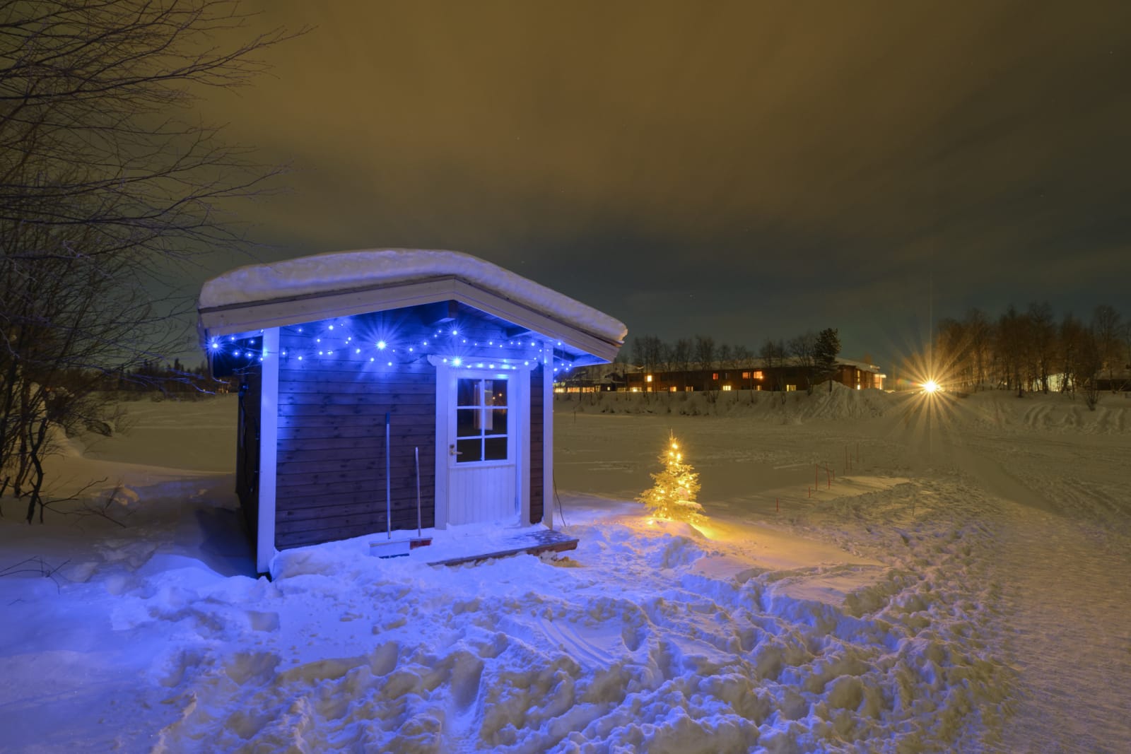 Sauna at night in the snow covered in lights