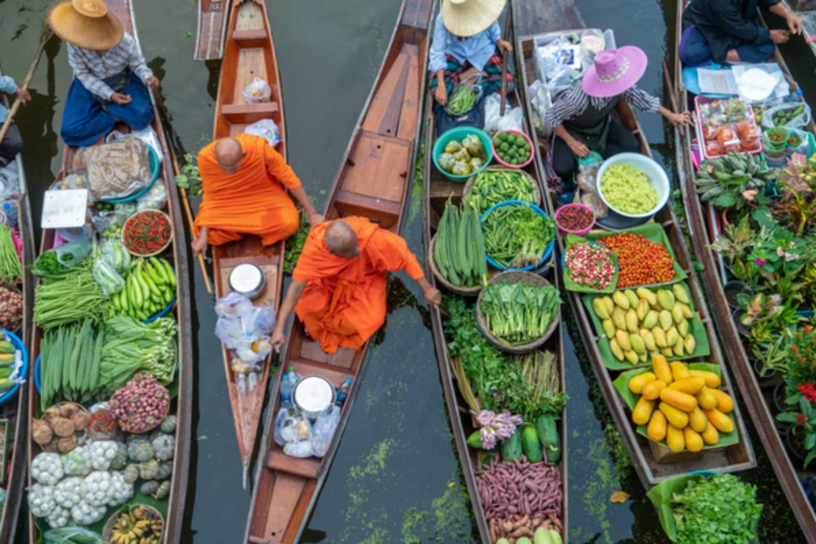 boats full of food and vegetables floating on water in thailand