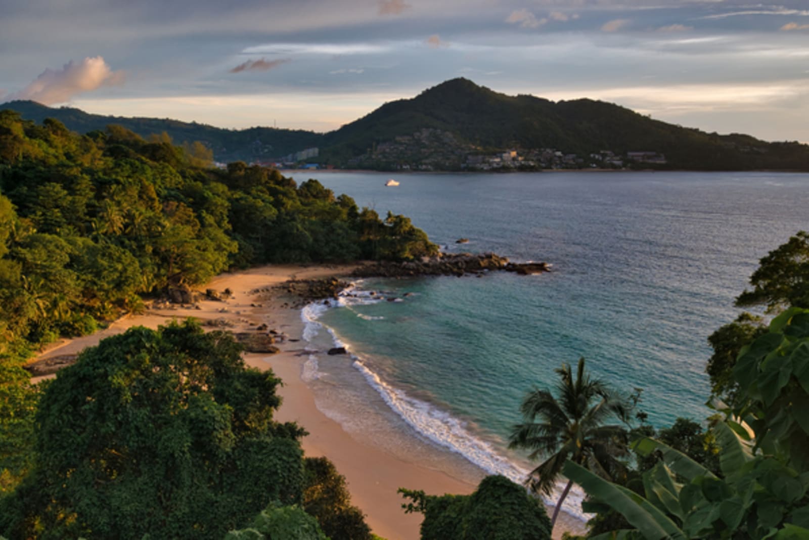phuket beach at sunset with mountains in background