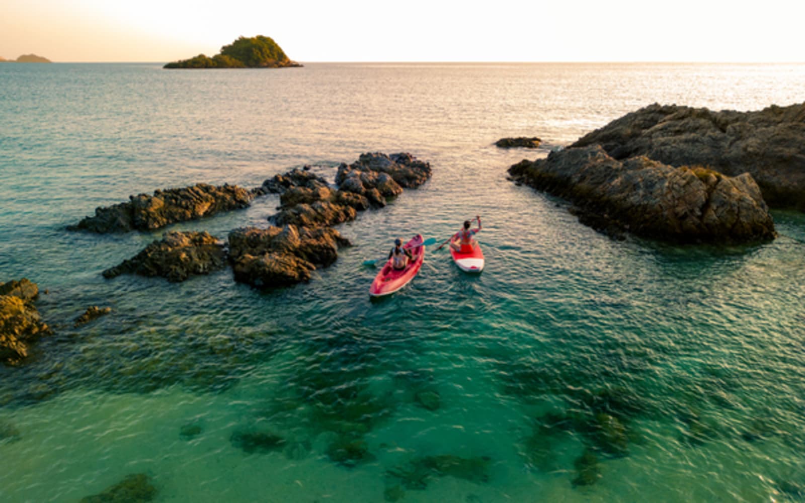 Two people kayaking at sunset 