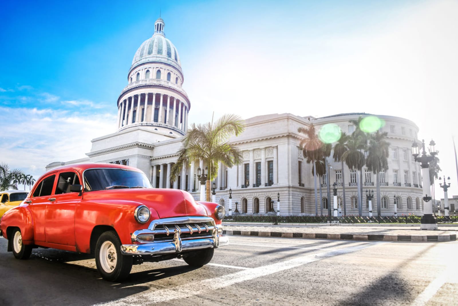 Red Authentic Vintage Car Moving In Front Of El Capitolio In Havana, Cuba