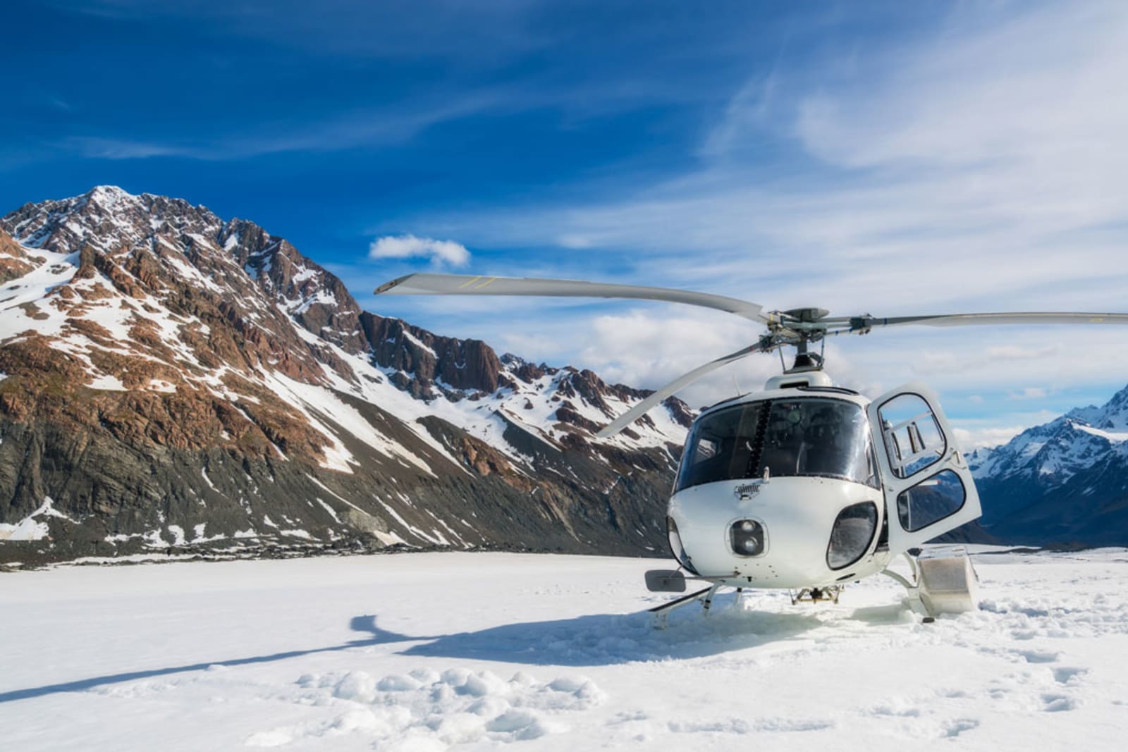 Helicopter landing on snow mountain in tasman glacier in Mt Cook, New Zealand
