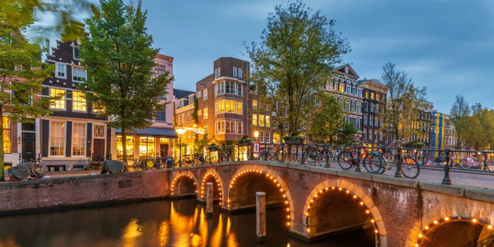 A bridge in Amsterdam lit up at night.