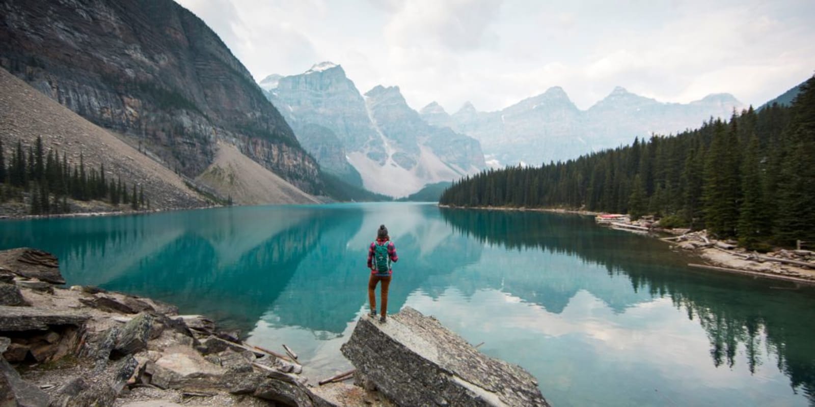A person standing on a rock looking out over a lake in Canada
