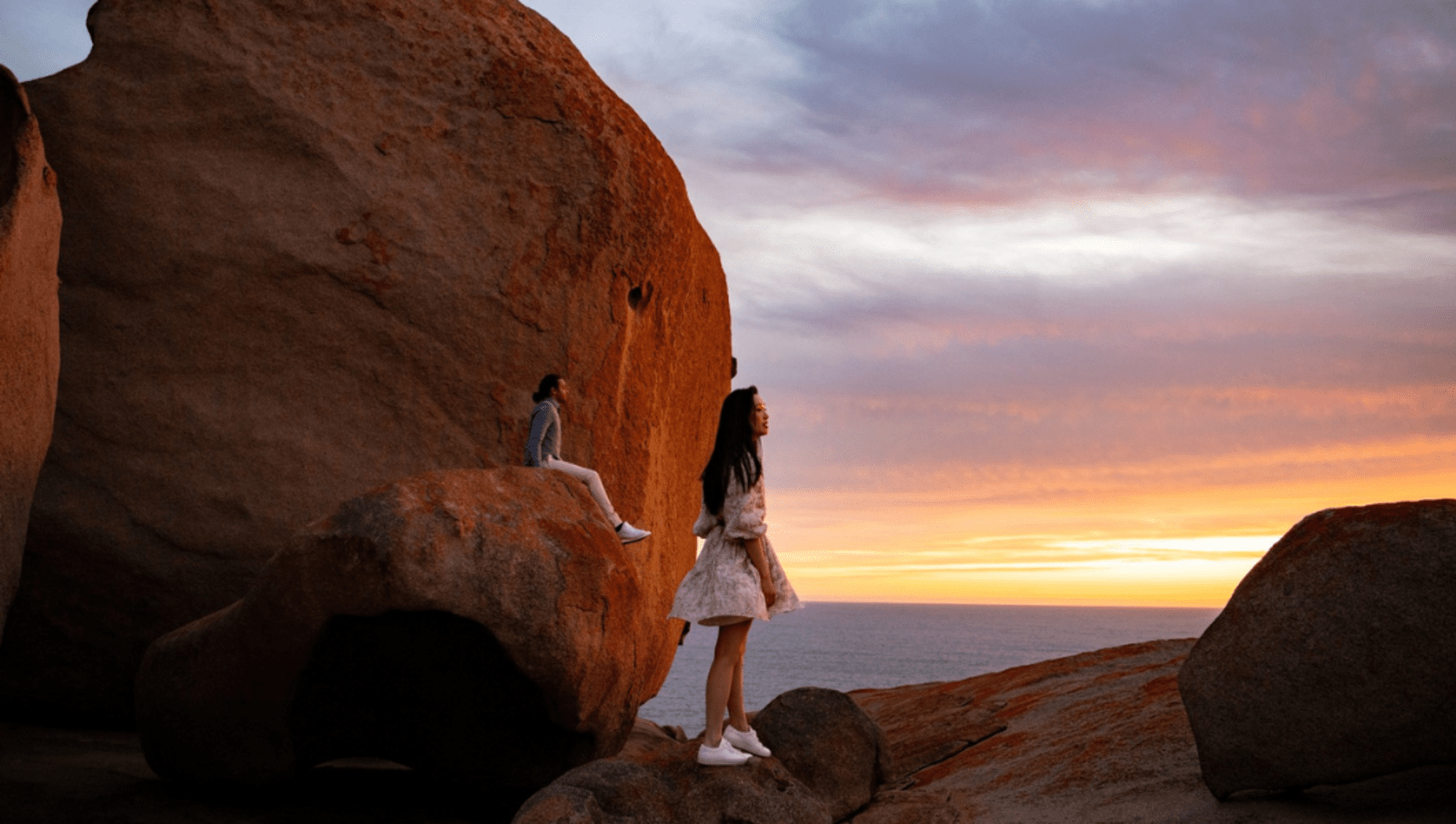 Two people next to a natural stone structure at Remarkable Rocks 