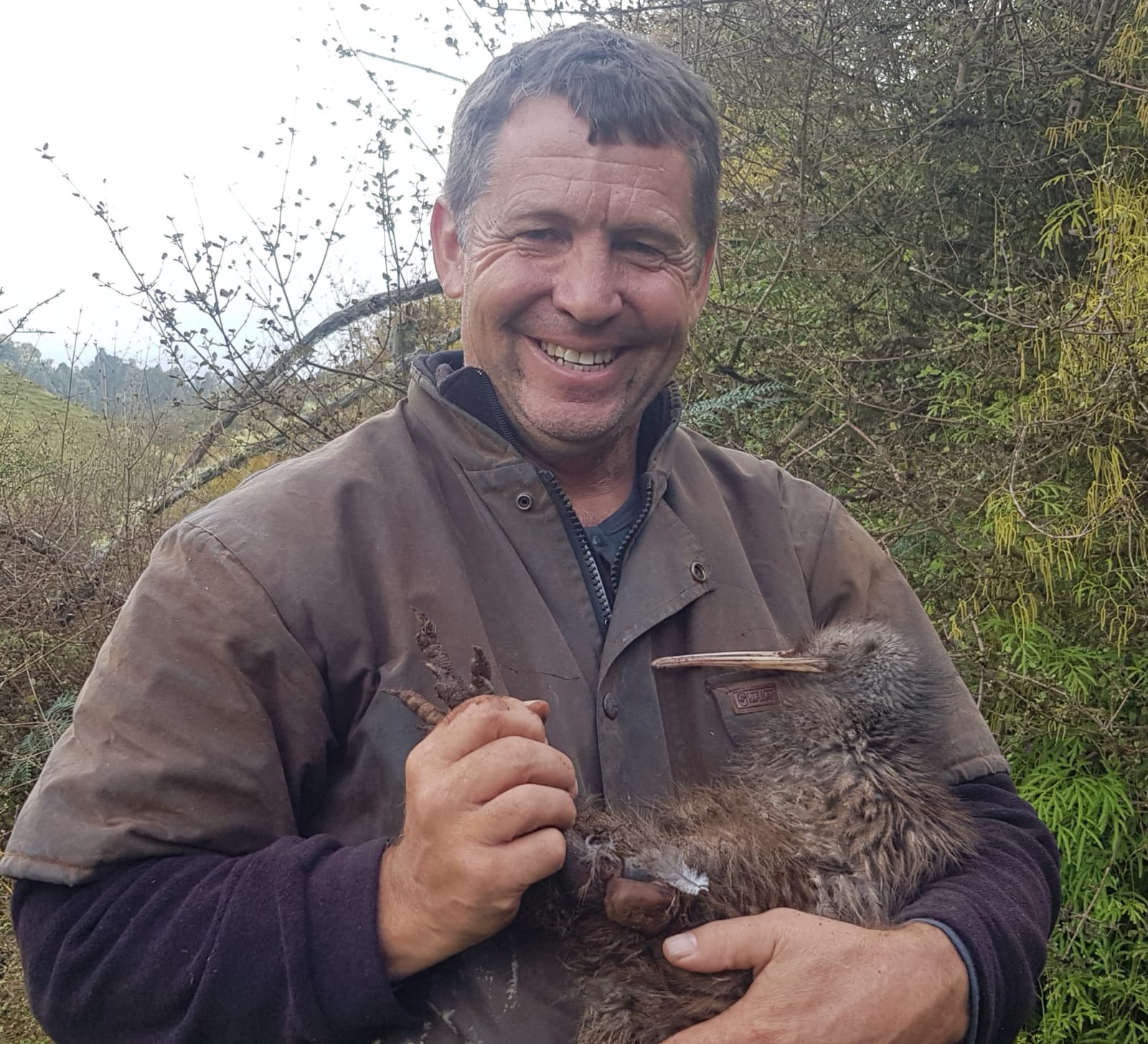 Reserve manager cuddling a wounded Kiwi Bird