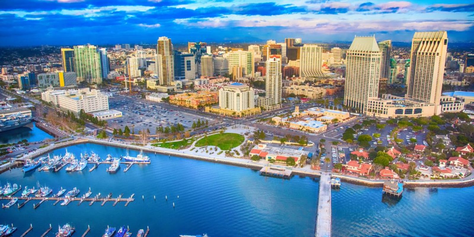 An aerial view of down town San Diego with a marina, tall buildings and blue water