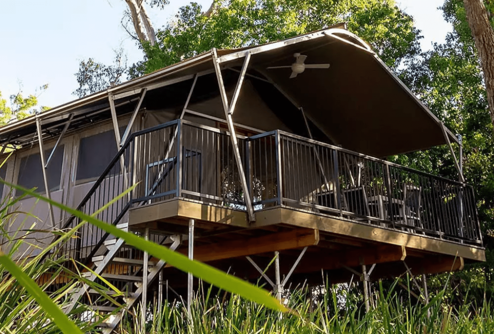 An elevated safari tent in bushland.