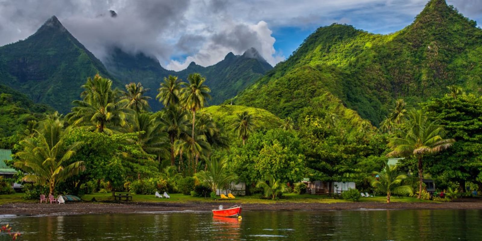 A boat in the water with green mountains in the background