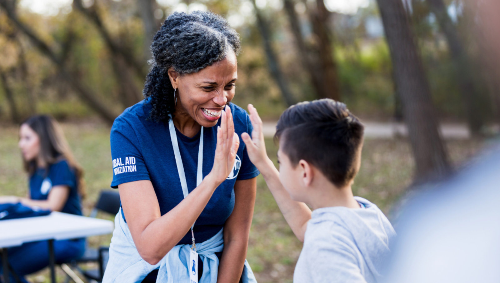 Female volunteer high fiving young child