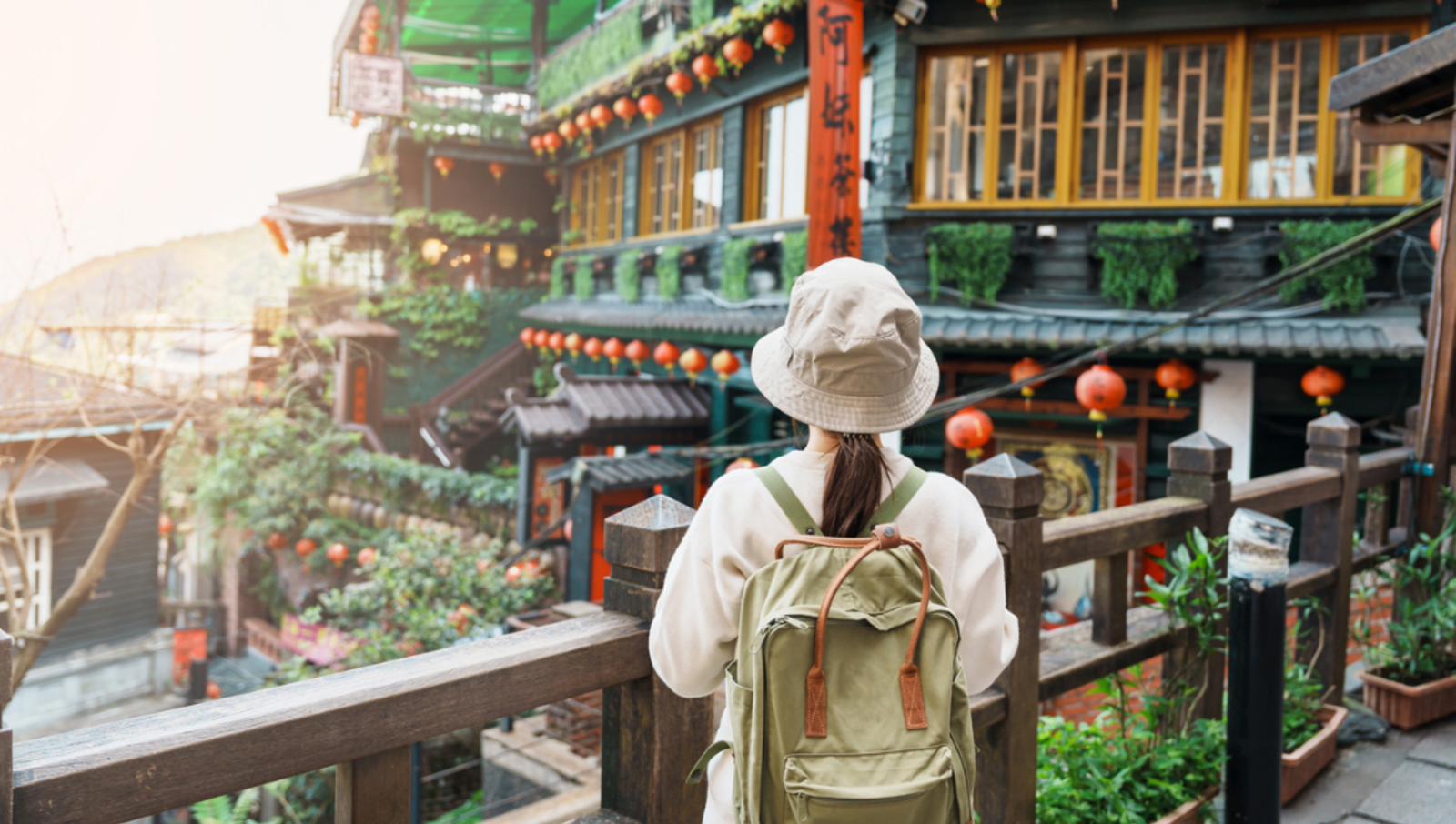 lady with bucket hat looking out at traditional building in taipei