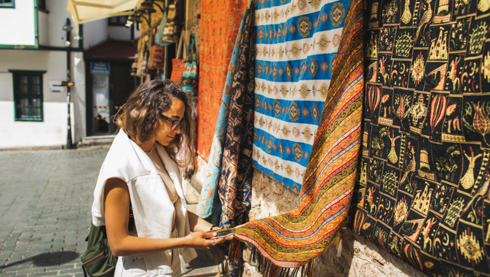 Lady holding tapesty hanging at a local market