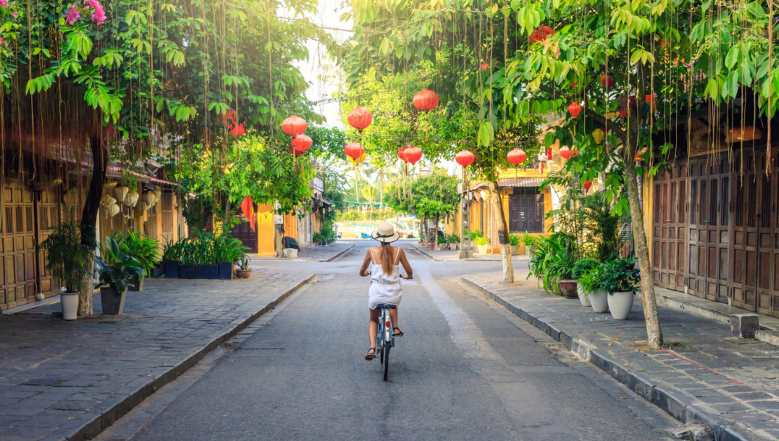 Lady riding bike down street in vietnam