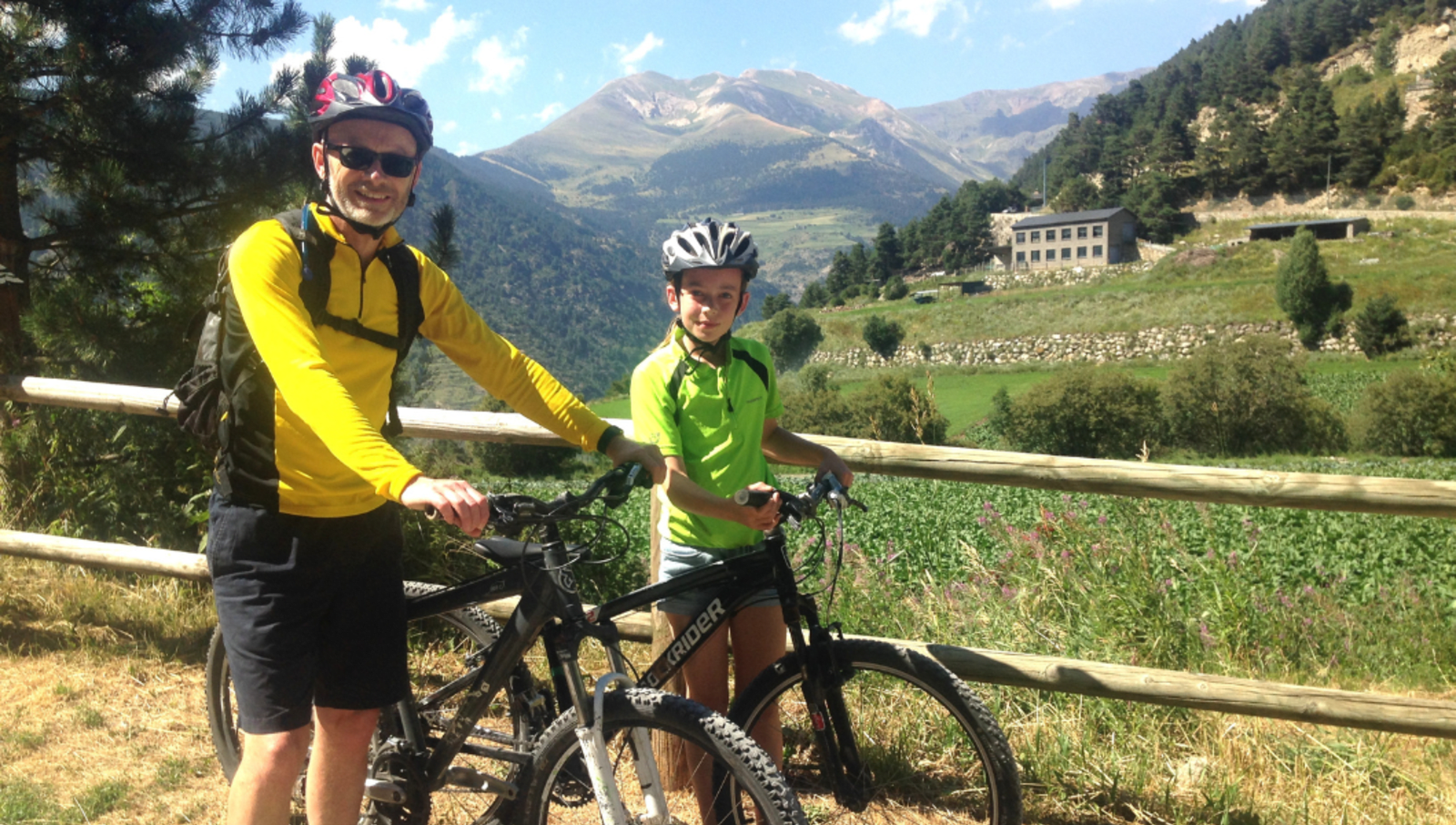 Dad and son smiling for photo with bikes