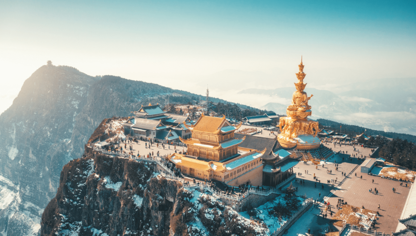 gold buddhist temples on top of tall mountain with light snow 