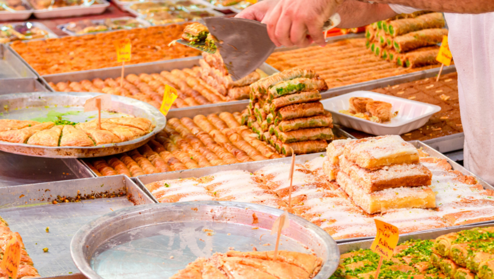 large trays of middle eastern desserts being distributed 