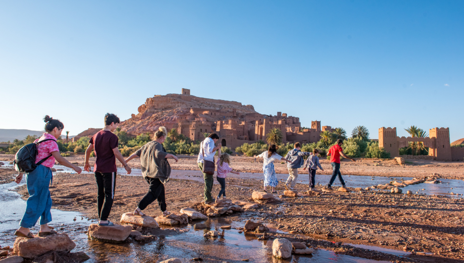 family members standing on stones in river