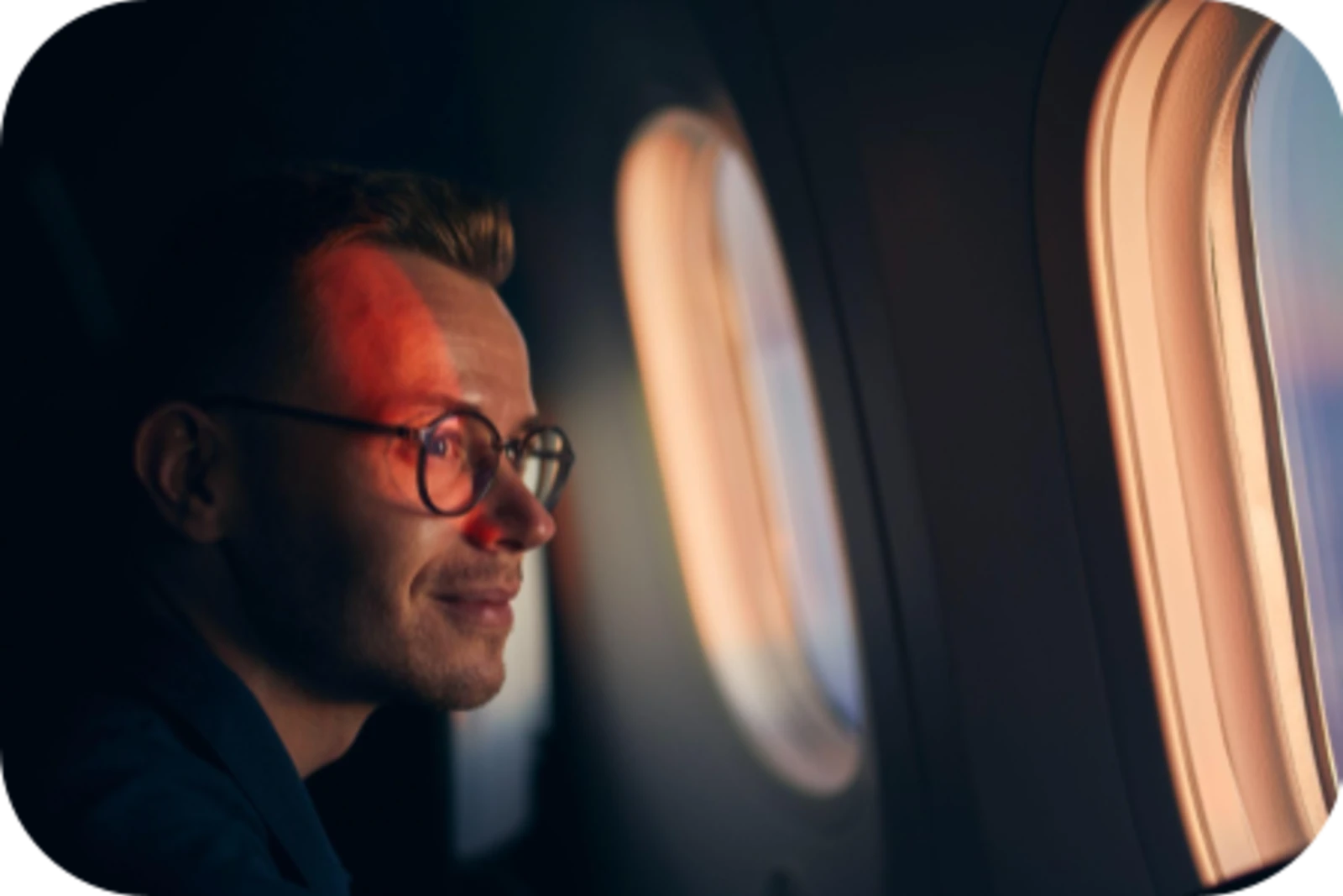 a gentleman is looking out the windows in the airplane and enjoying the view.