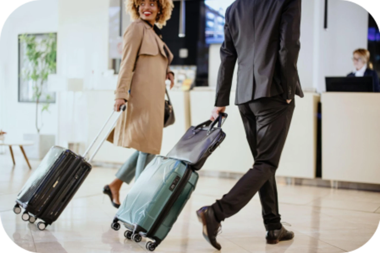 a gentleman and a lady are carrying their luggage to check-in counter 