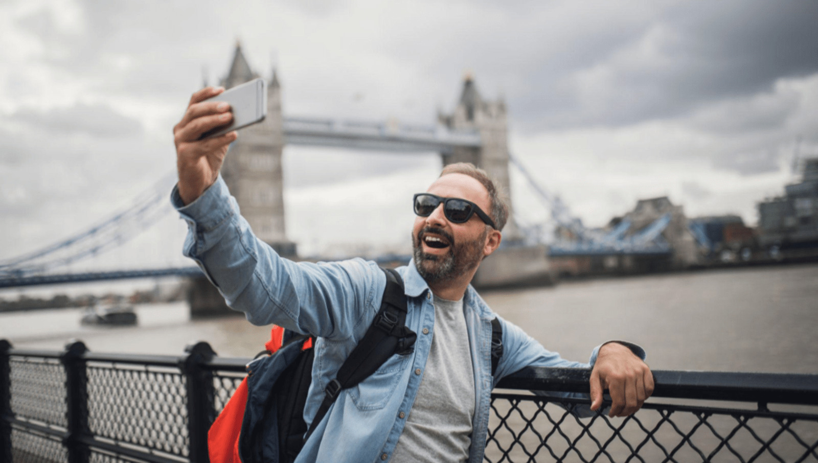 Many taking selfie in front of london bridge 
