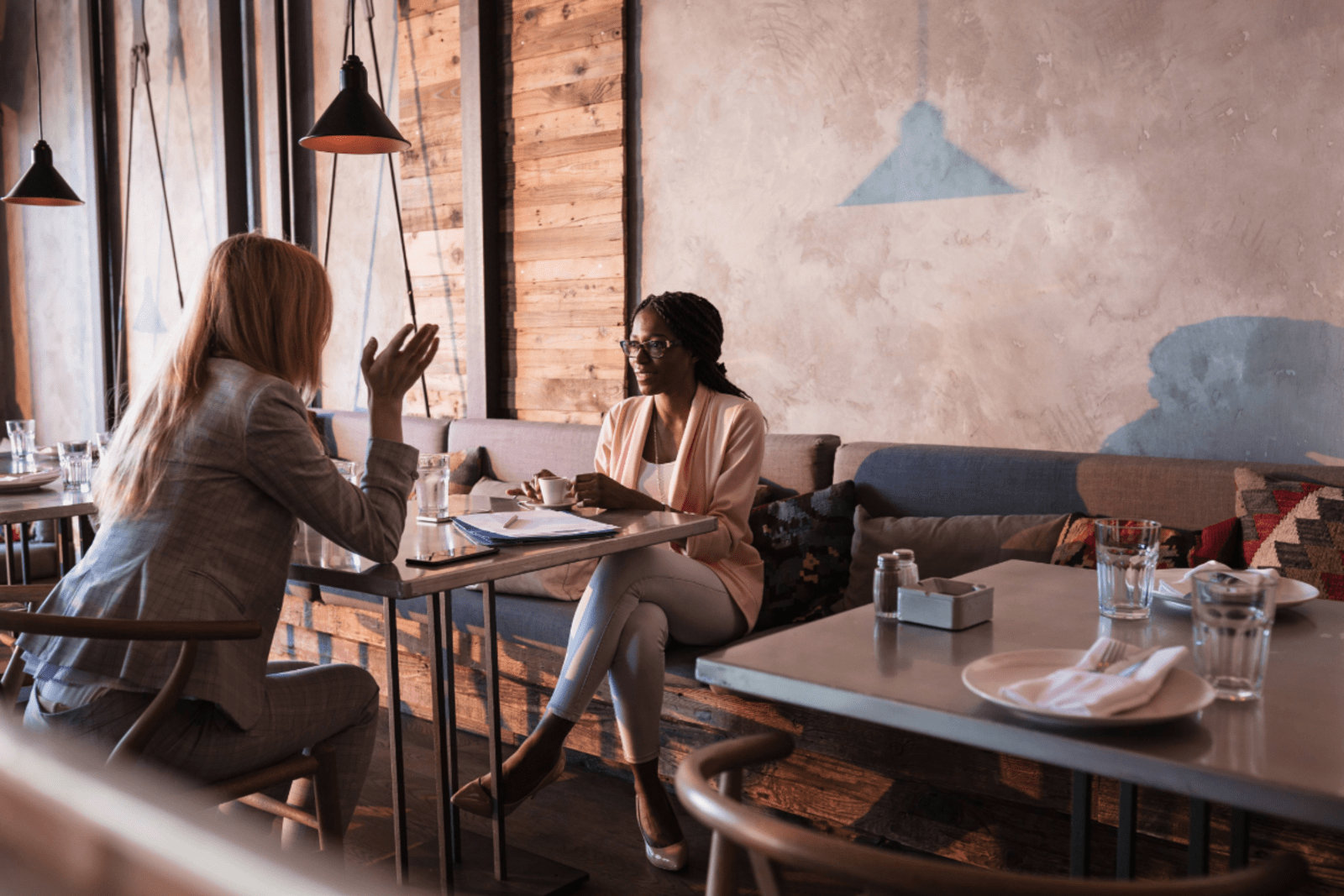 two business women sitting at a table in a coffee shop having a meeting