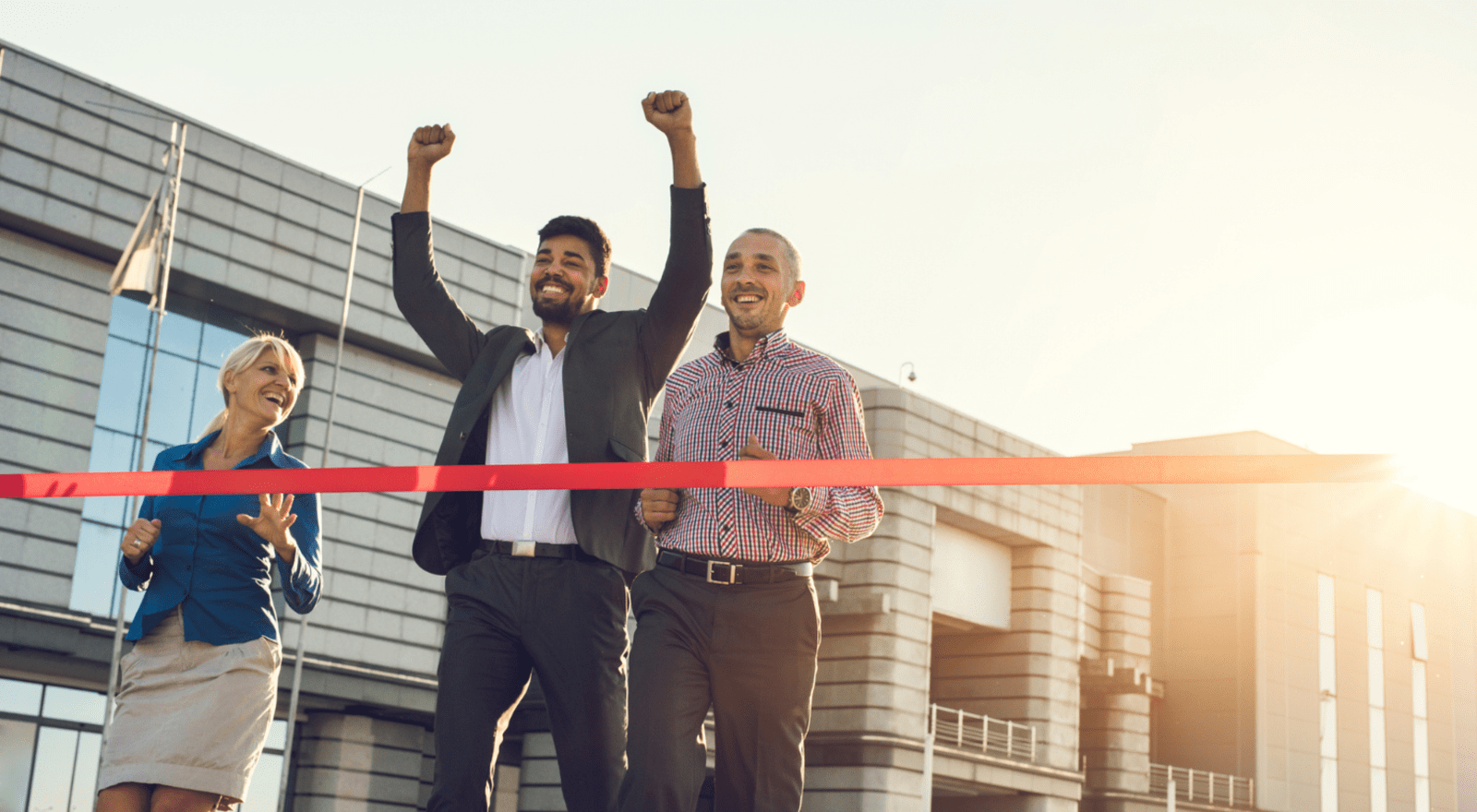three business people running towards red tape in a race