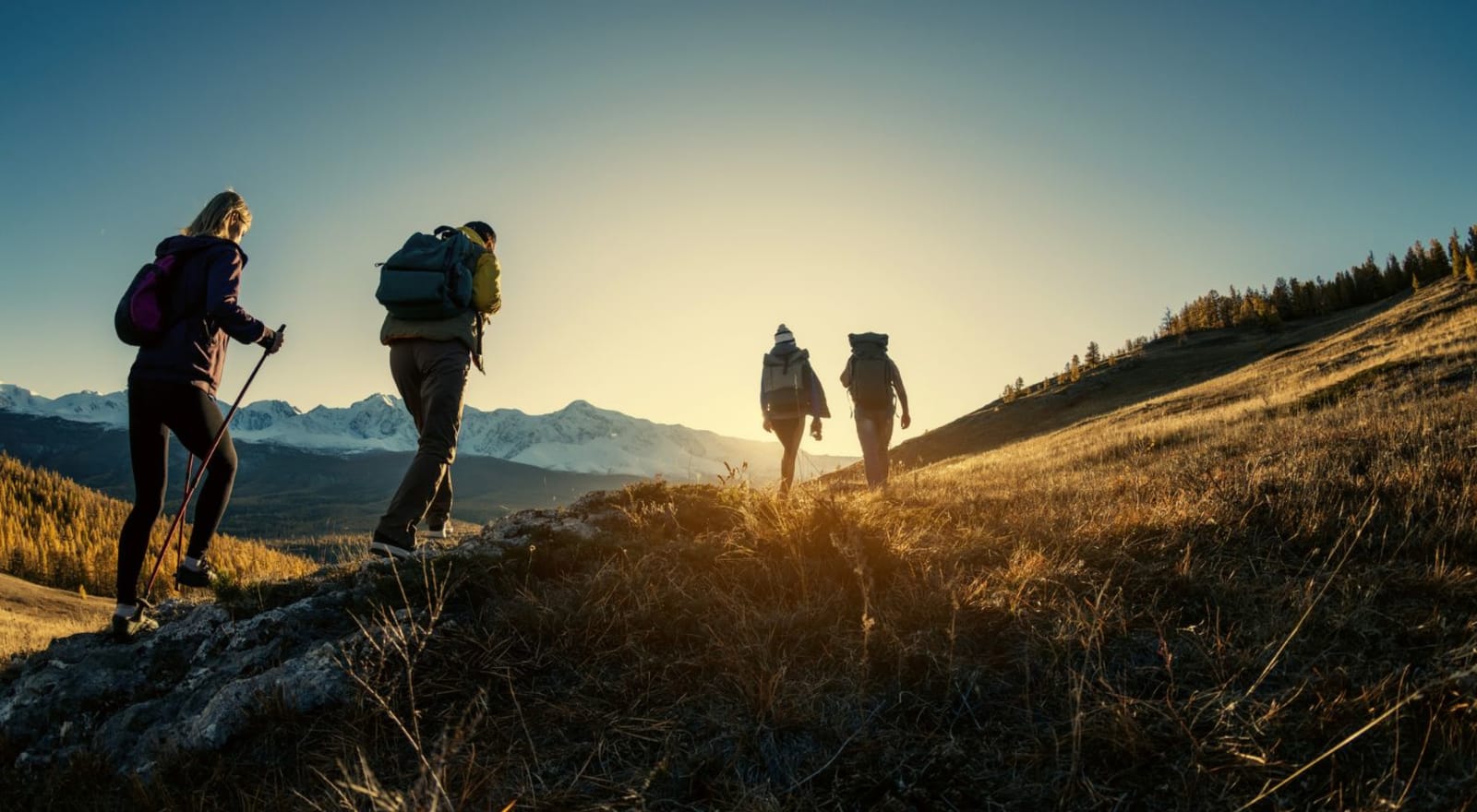 group of four people hiking mountain 