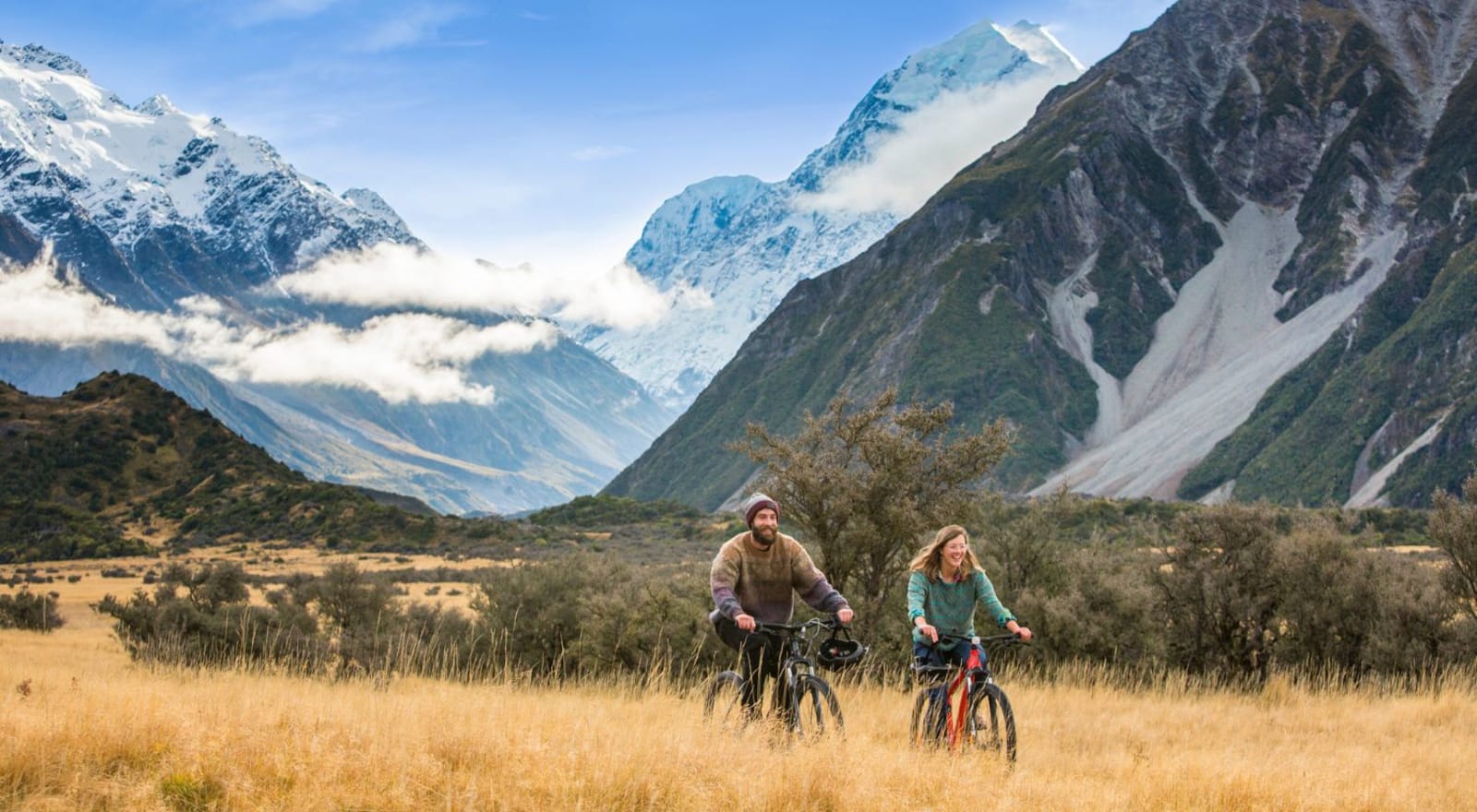 couple cycling though national park beside mountains