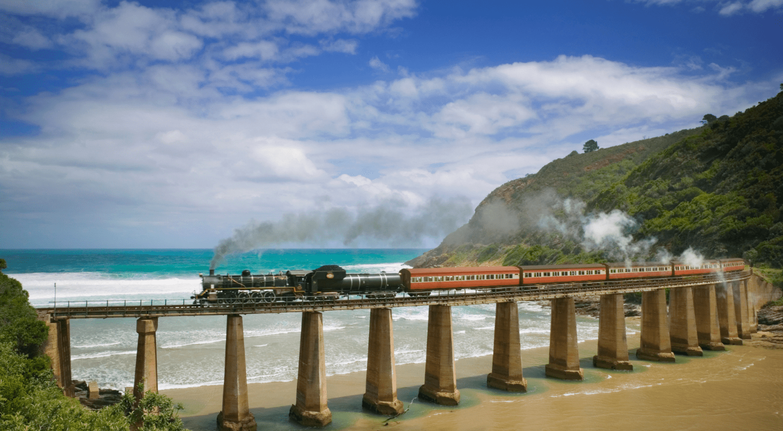 train running on bridge over beach in south africa