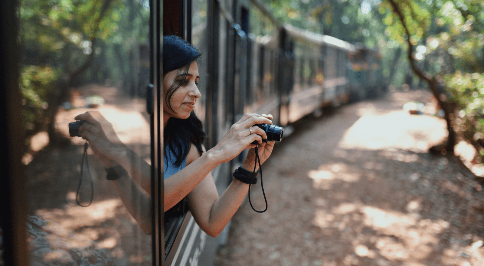 lady with camera taking picture out of window on train