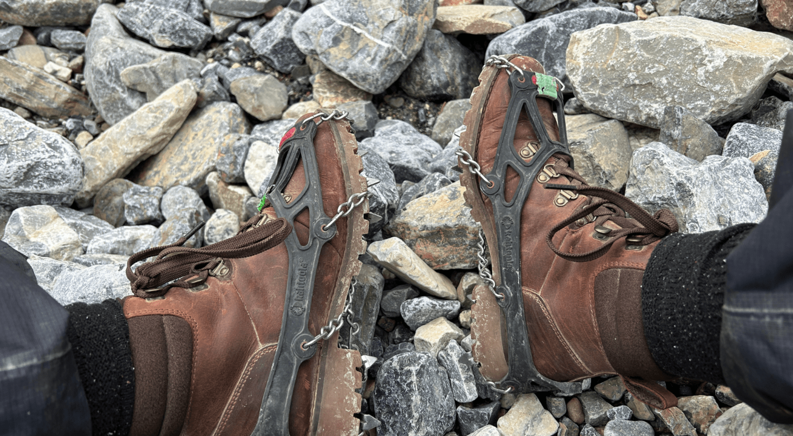 brown walking boots with crampons attached for ice walking