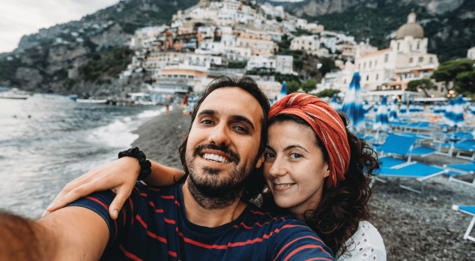 younger couple taking selfie on beach of amalfi coast