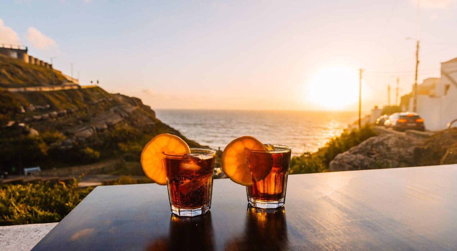 two cocktails on a table overlooking the ocean 