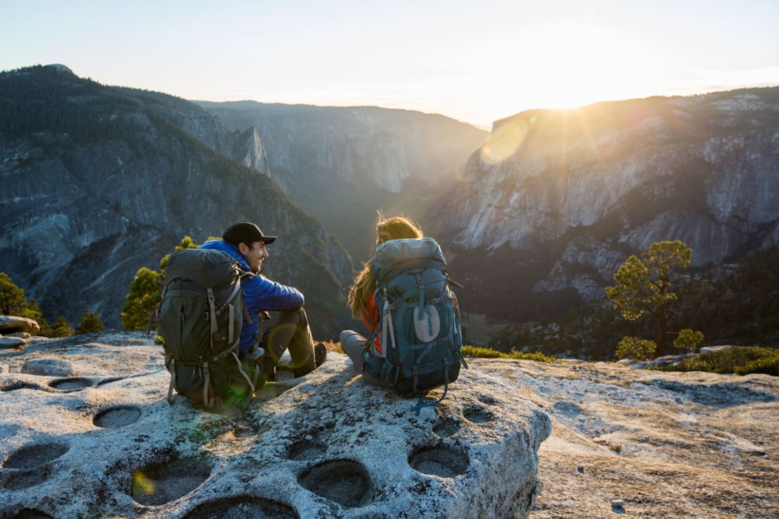 A couple sitting on a ledge while backpacking in Yosemite Valley