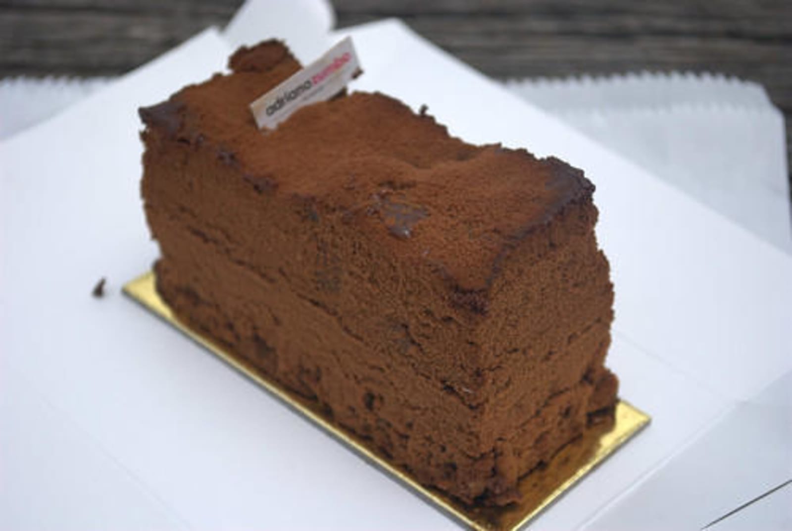 A thin slice of light brown cake, likely chocolate flavoured