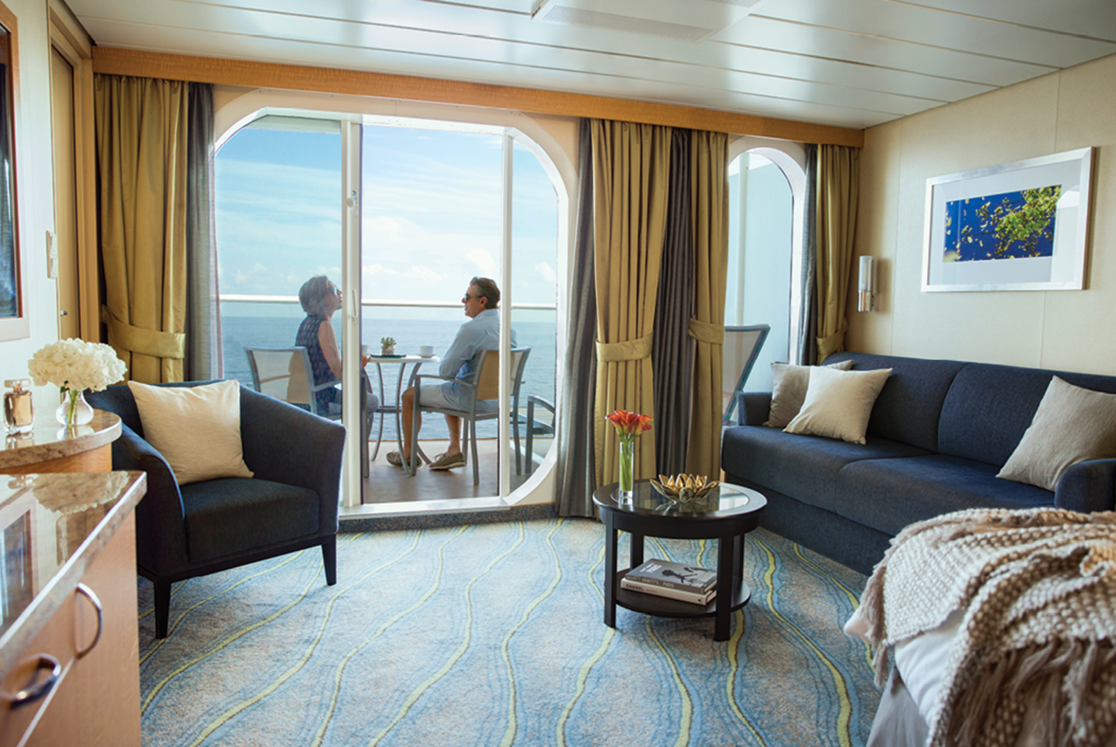 A couple sitting on their cruise stateroom balcony