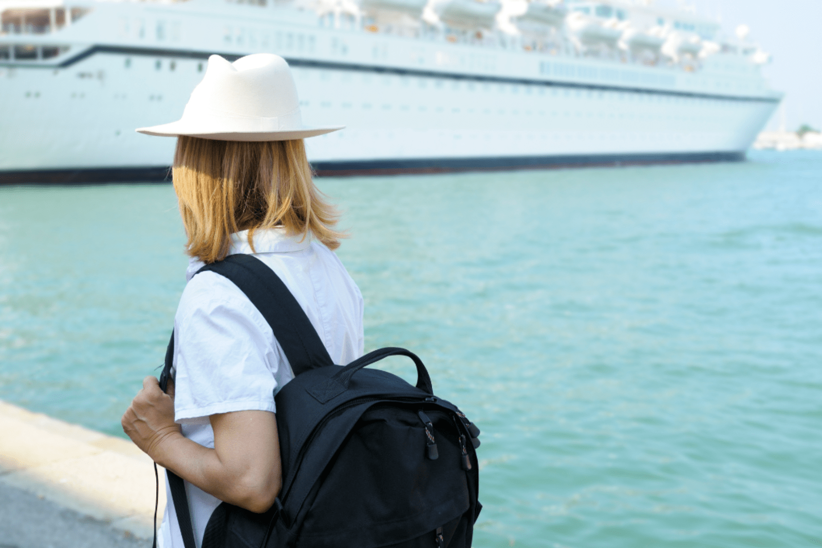A woman walking toward where her cruise ship is docked