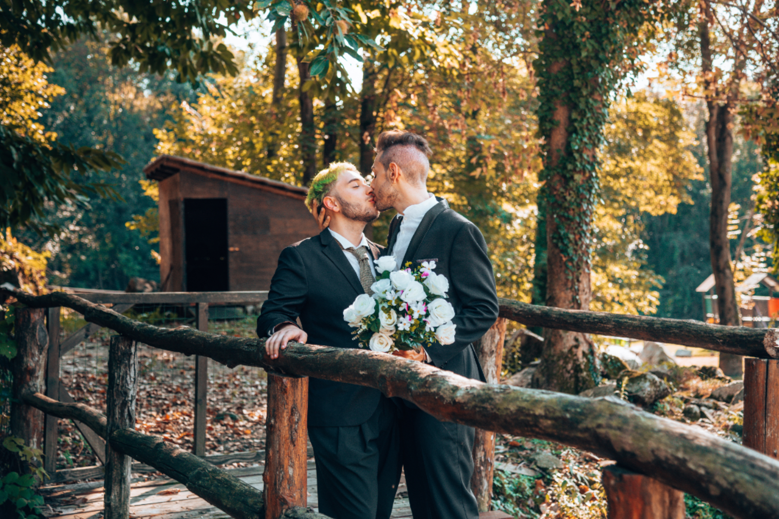 Grooms kissing during their fall mountain wedding
