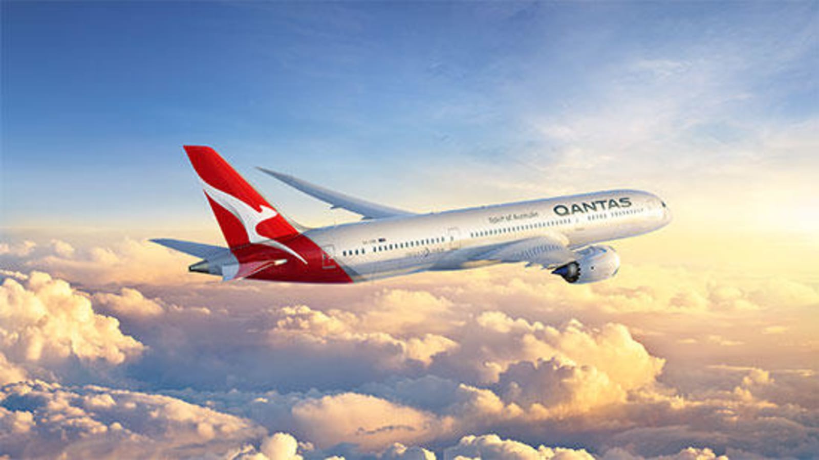 Qantas plane flying in the clouds, heading towards a vibrant sunset