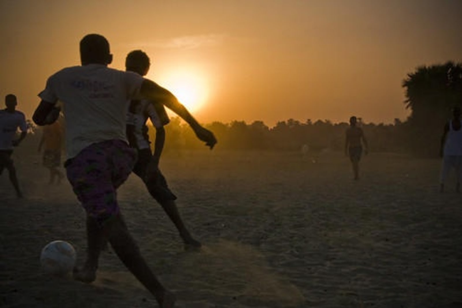 People playing football on the banks of the Nile.