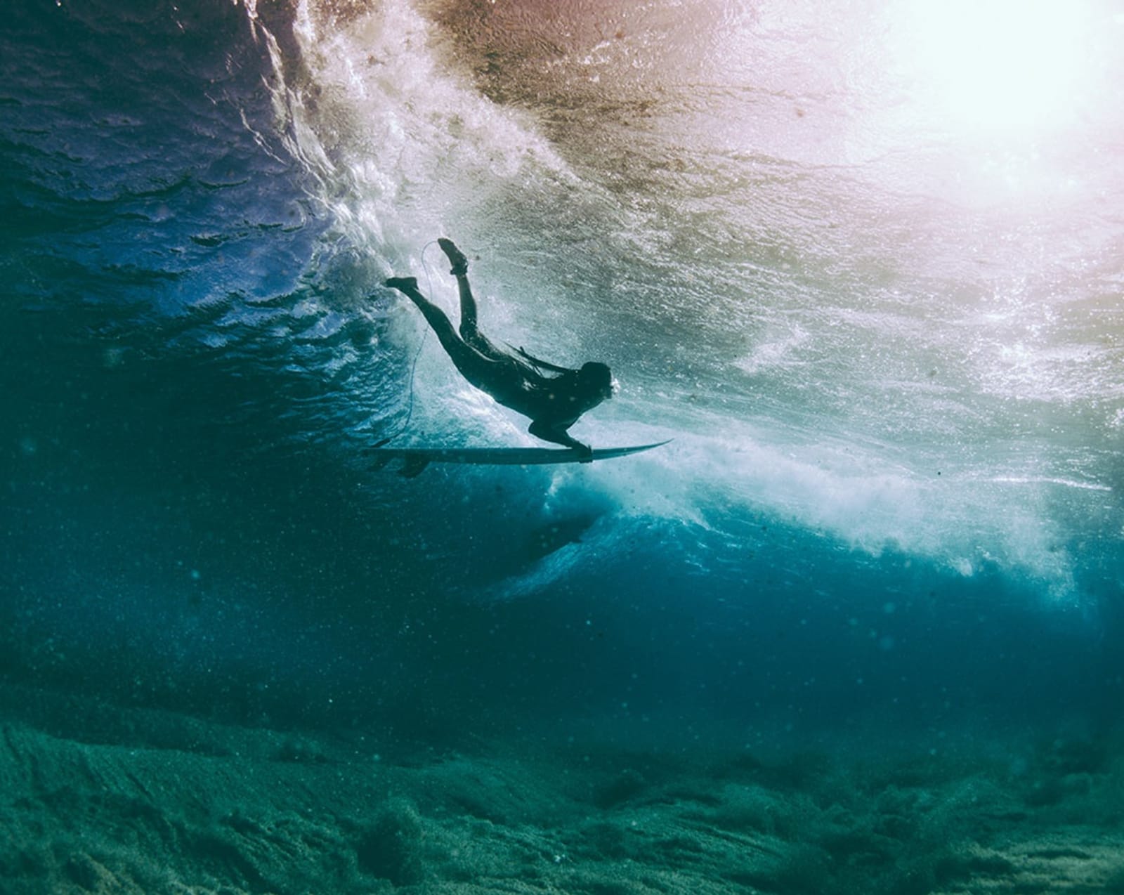 Surfer diving under wave