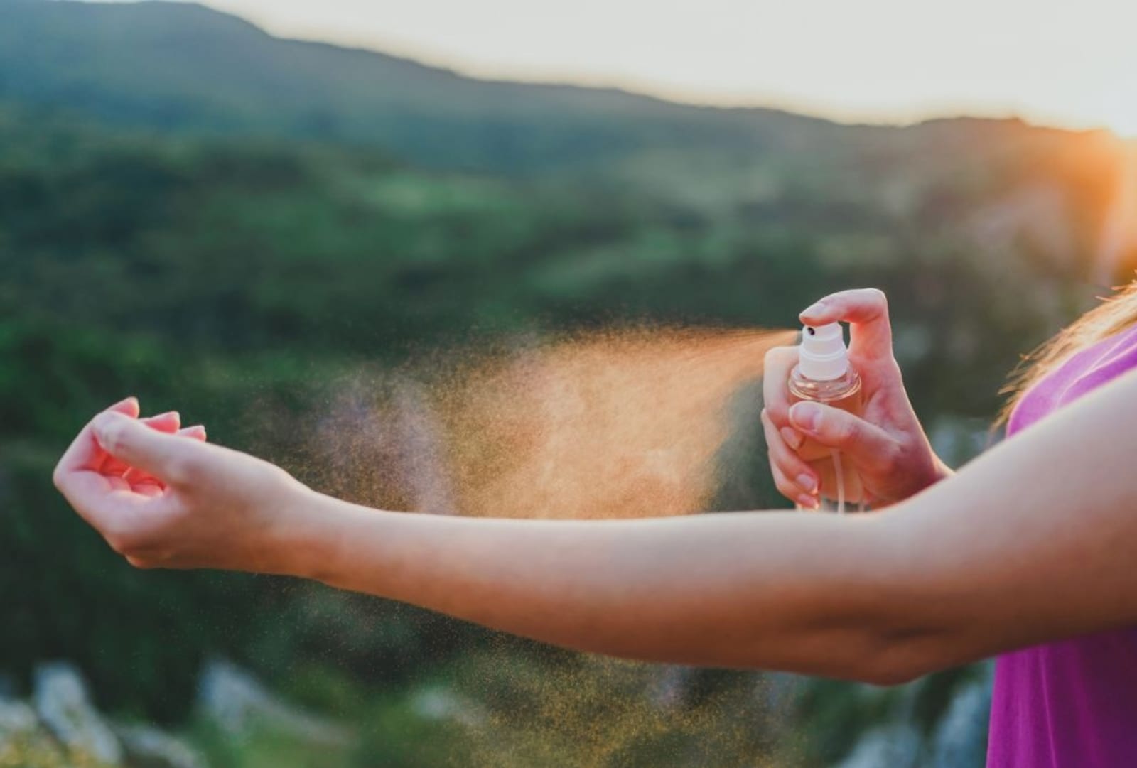 Image of someone applying insect repellent