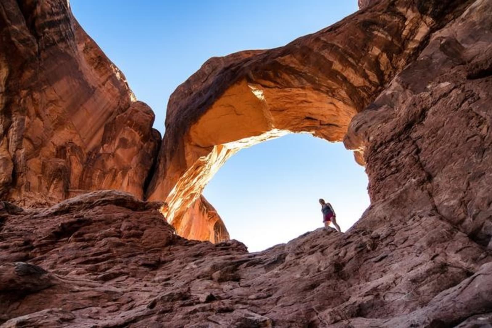 a_woman_stands_beneath_double_arch_in_arches_national_park_near_moab_in_utah_getty_images.jpg