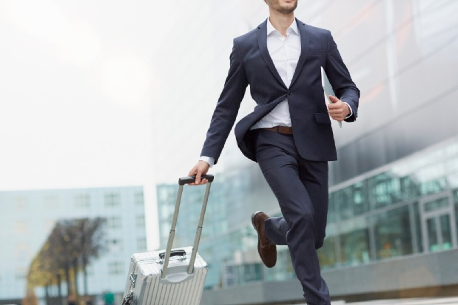 Man running in airport holding luggage
