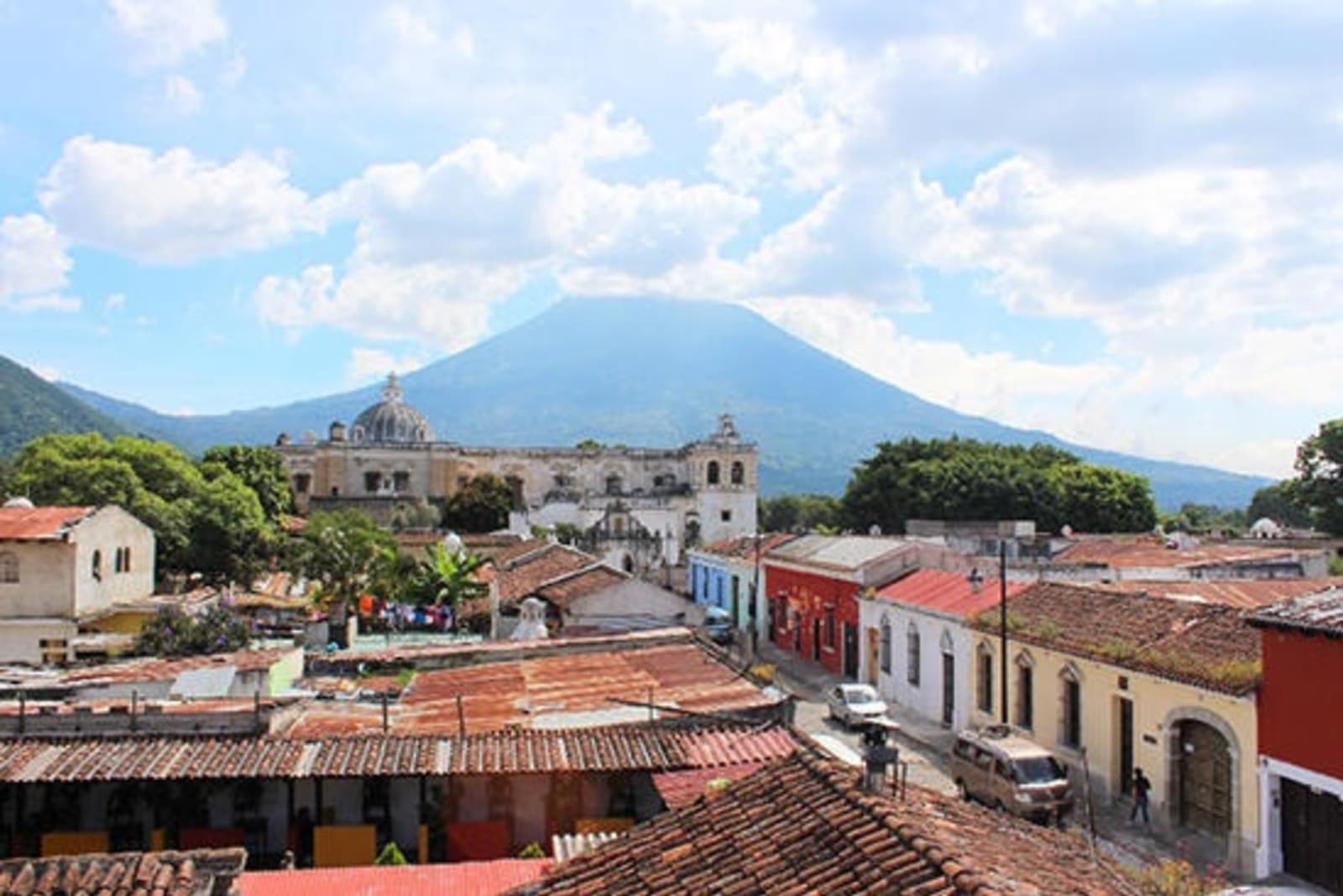 View over rooftops in Guatemala with volcano in the background.