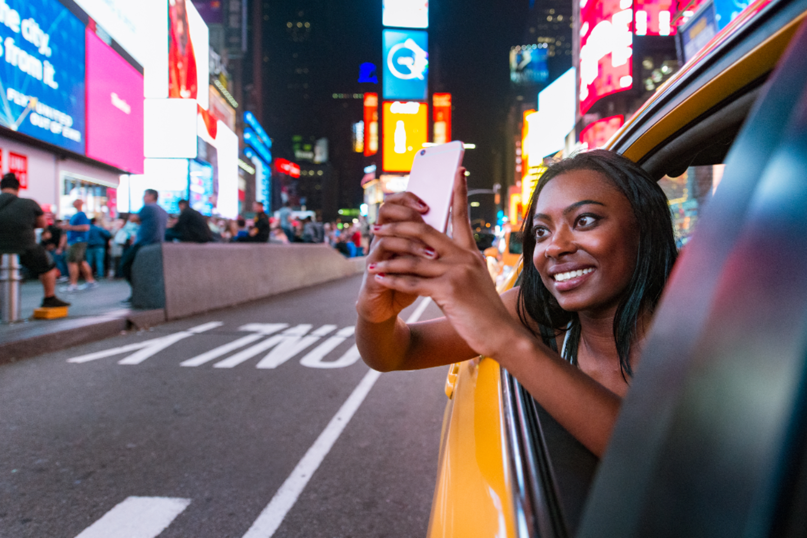 Woman taking photos from the backseat of a NYC taxi