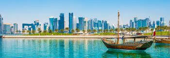 A dhow boat moored with the Doha cityscape in the background
