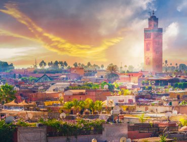 View of marrakesh city with sun shining behind clouds in the background