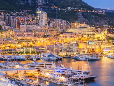 Marina lite up with city lights dusk time, Monaco